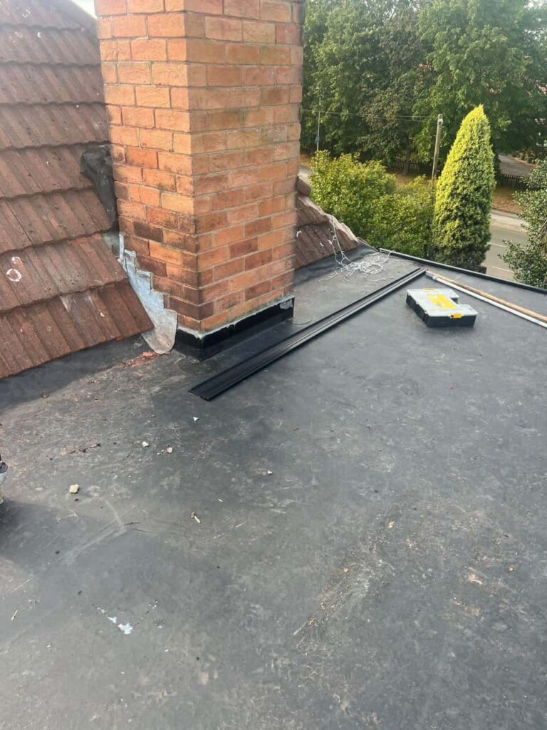 This is a photo of a flat roof which has just been repaired, there is also a chimney stack and some leadwork has also been dressed. Works carried out by Cambourne Roofing Repairs